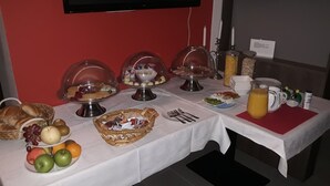 Un bufé de desayuno con diversas opciones de comida y un televisor en la pared.