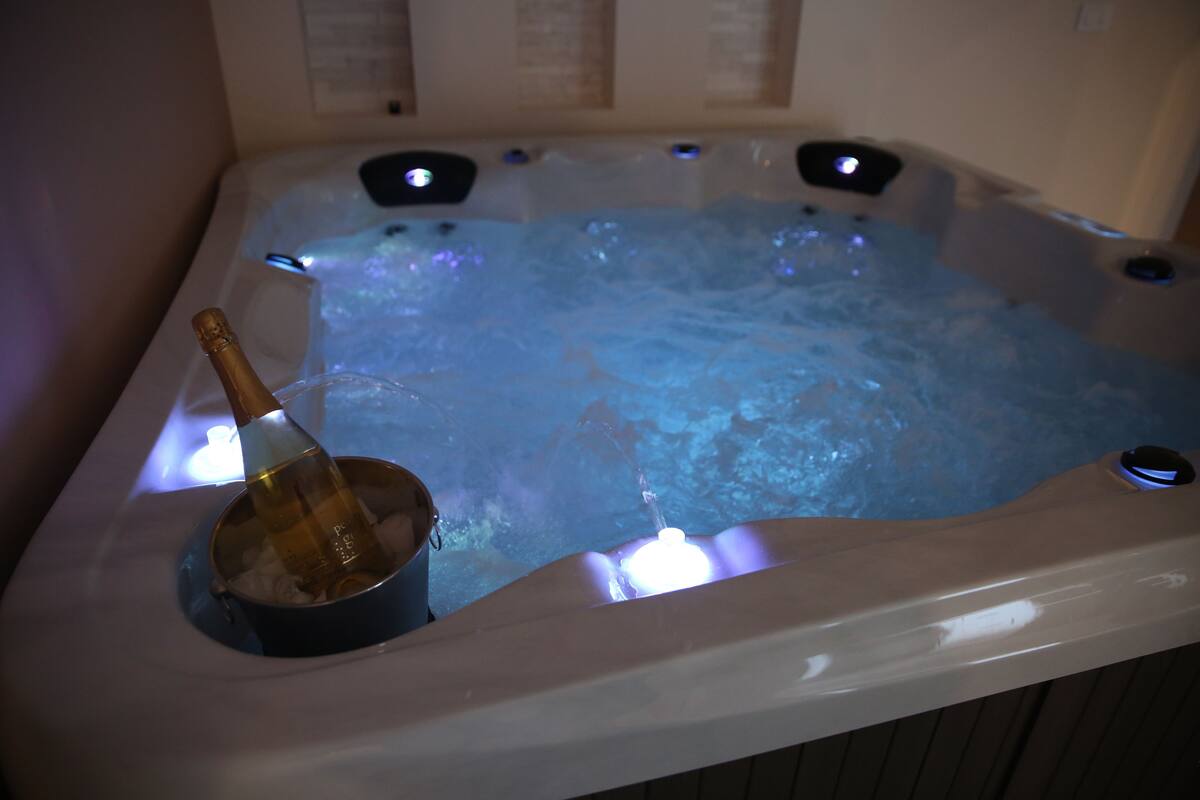 A hot tub with a bottle of champagne.