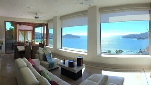 A spacious living room with a large window offering a view of the sea and hills. - Spectacular luxury penthouse at La Ropa beach, unique view, private rooftop pool (Playa la Ropa)