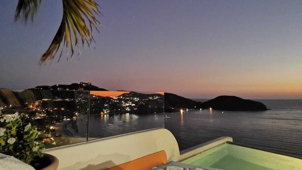 A coastal view with a cityscape at dusk, a swimming pool, and a palm tree. - Spectacular luxury penthouse at La Ropa beach, unique view, private rooftop pool (Playa la Ropa)