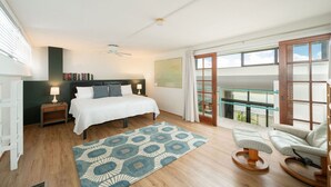 A bedroom with a bed, bedside tables, a reading chair, a balcony with a view, and a ceiling fan. - Exclusive Key West Beach Front - 2BR Luxury Condo w/Gym and Pool Access (Newly Refurnished!) (Key West)
