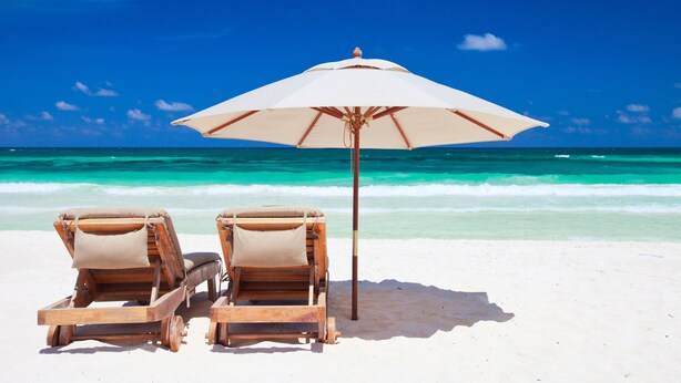 Two wooden lounge chairs with beige cushions and a large white umbrella on a sandy beach with clear turquoise water and a blue sky. - SEASCAPE SUMMER SPECIAL/Golf Course Villa-2BR/LakeView/PET OK/Short Walk toBeach (Miramar Beach)