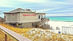 A beachside building named 'Whale's Tail' with a wooden deck and a view of the ocean. - SEASCAPE SUMMER SPECIAL/Golf Course Villa-2BR/LakeView/PET OK/Short Walk toBeach (Miramar Beach)