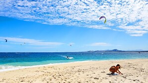 A beach with clear skies, a sandy shore, and a person in a swimsuit. - Sweeping ocean views steps to beach w/pool & Firepit. Close to Tres Palapas!  (Los Barriles)