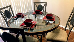 A round glass table with six chairs, each with a cushioned seat and backrest. - Beautiful 3bd/3ba Phoenix Home near Downtown Area, ASU! (Phoenix)