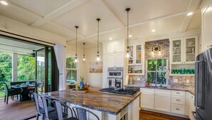 Una cocina moderna con una isla grande, armarios blancos y un horno empotrado.