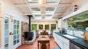 A modern kitchen with skylights, a dining area, and a fireplace.