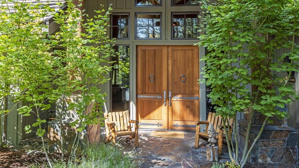 A lodge entrance with a wooden double door, stone steps, and a bench. - LUXURY RUSTIC LODGE IN BLACK BUTTE RANCH (Black Butte Ranch)