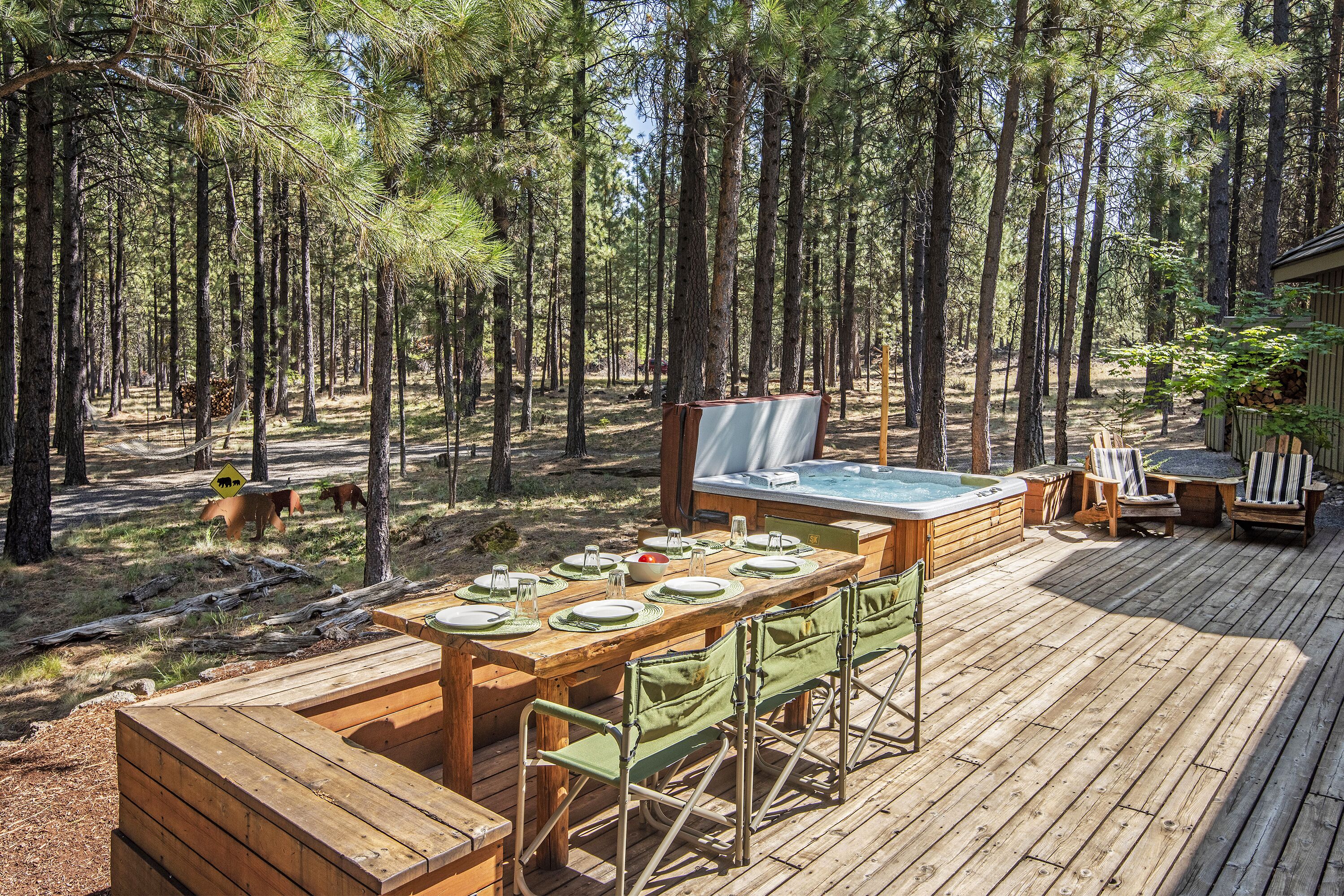 A wooden deck with a hot tub, dining table, and chairs.