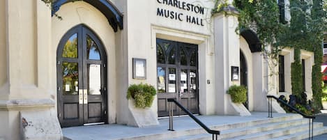 Experience the charm of the Charleston Music Hall's classic design, featuring an arched entrance and a welcoming staircase.