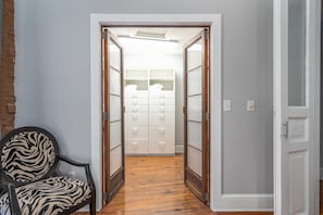 Enter a room with a wardrobe featuring multiple drawers and shelves, and a comfortable chair with a zebra print cushion.