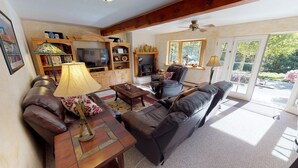 A living room with a sofa, a coffee table, a TV, and a fireplace.