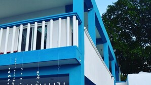 A modern building with a blue and white color scheme, featuring a staircase leading to an upper level. - Posada Maria Isabel (Celestún)