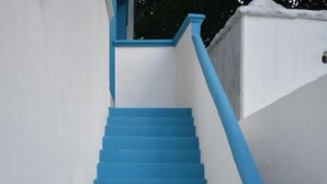A set of blue stairs leading up to a white wall. - Posada Maria Isabel (Celestún)
