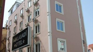 Un hotel de varios pisos con un letrero que dice 'MALABADI HOTEL'.