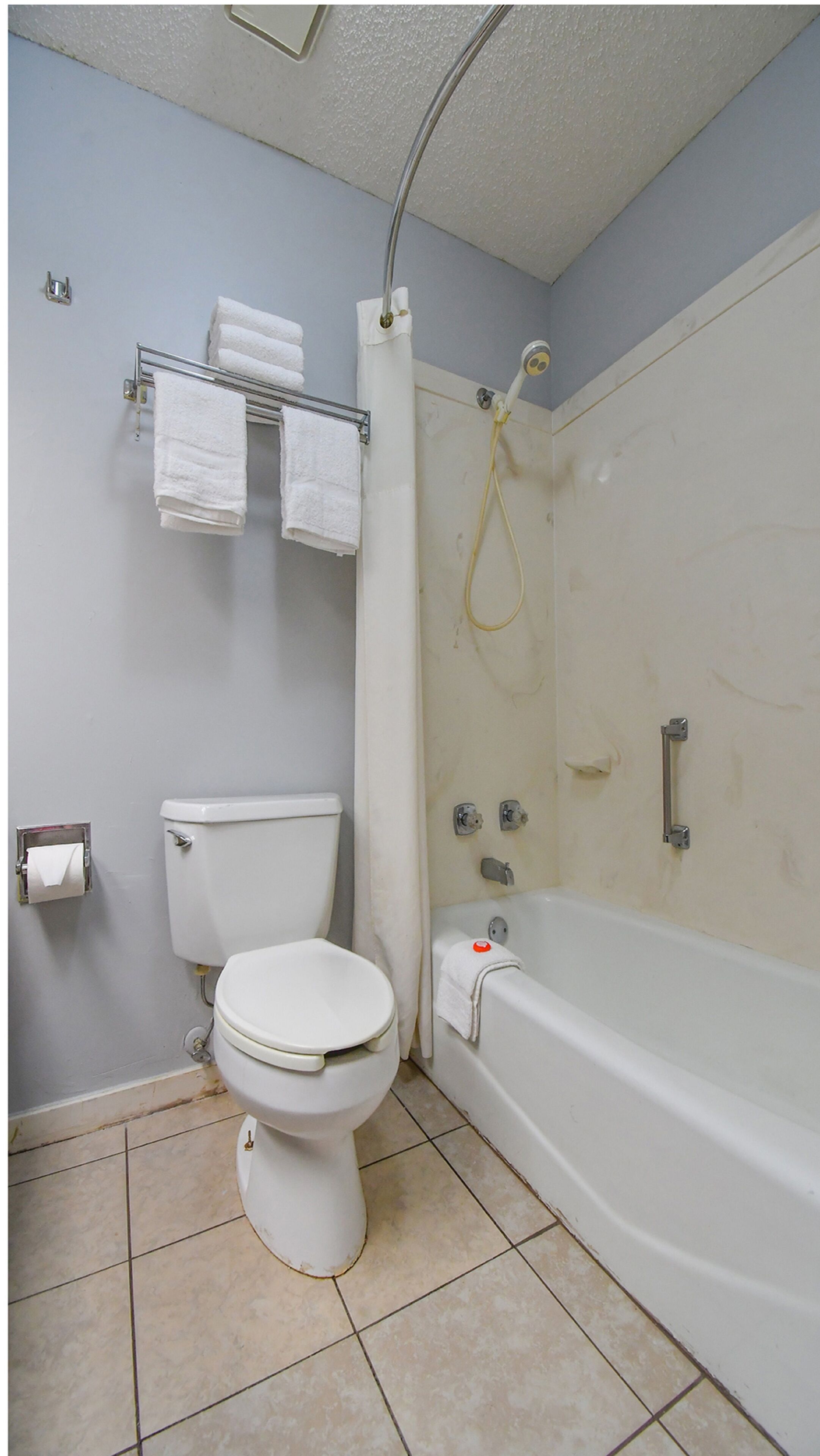 Un baño con inodoro, bañera y cortina de ducha.