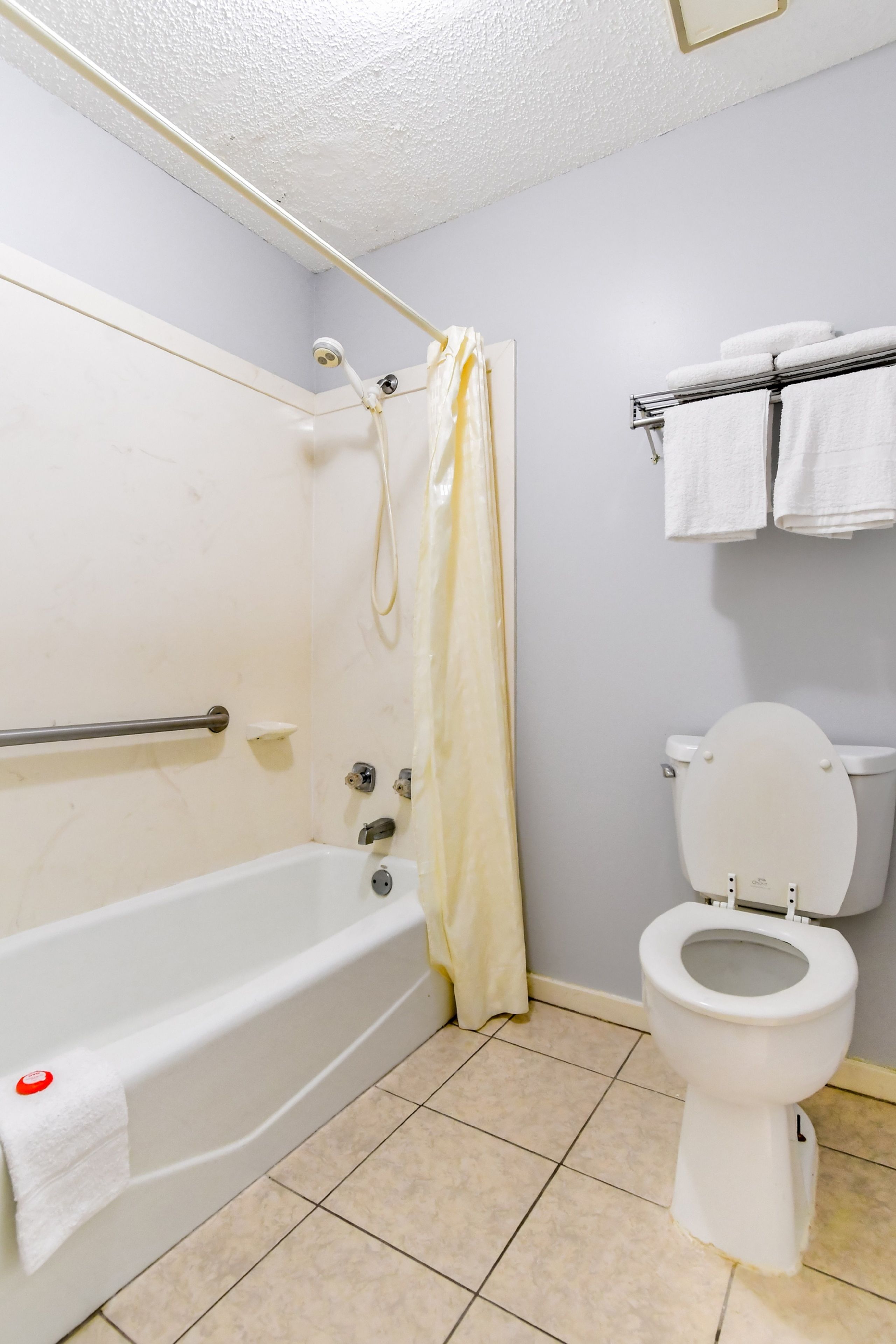 Ein Badezimmer mit Badewanne, Toilette und Handtuchhalter.