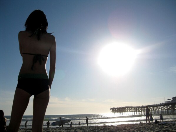 A beach scene with a pier in the background. - Breathtaking Ocean Front Pacific Beach Apt. (San Diego)