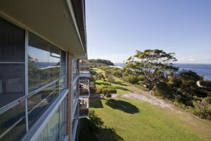 A modern building with large windows overlooking a coastal landscape.