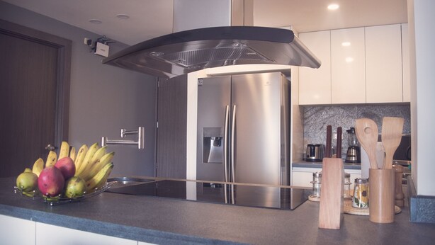 A modern kitchen with a stainless steel refrigerator, a fruit bowl on the counter, and wooden utensils. - Family_ friendly (Cuenca)