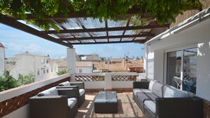 A covered outdoor seating area with wicker furniture and a glass coffee table. - Holiday rental townhouse with swimming pool in Begur, Centre (Begur)