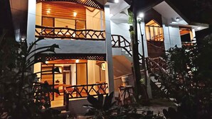 A two-story building with a balcony and a staircase. - Bruce Beach Resort (San Juan)