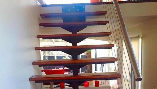 A wooden staircase with a metal handrail, leading to an upper level. - Waterloo Cottage (Battery Point)