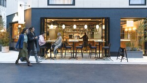 Een modern café met terras en een duidelijk zichtbaar menubord.