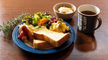 A plate of toast, scrambled eggs, and a salad with a cup of coffee on a wooden table.