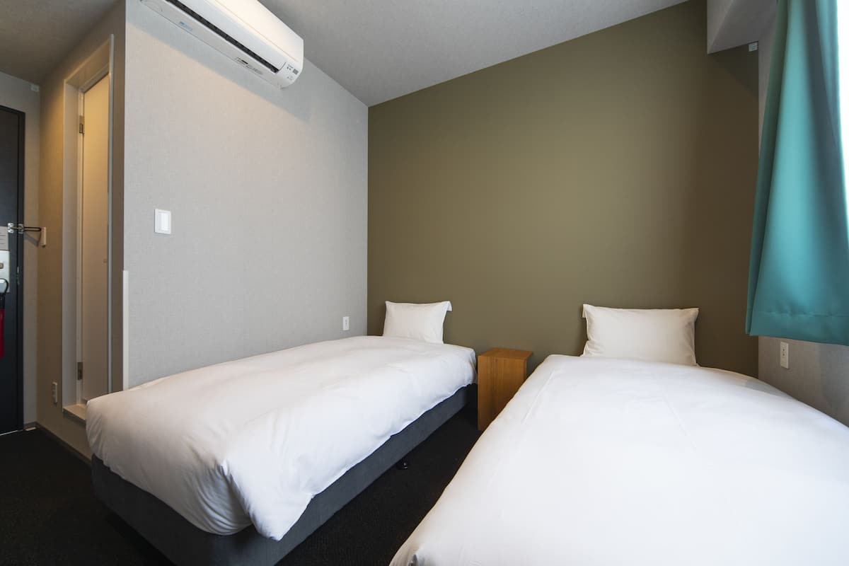 Eenvoudige Twin kamer, 2 eenpersoonsbedden | Een kluis op de kamer, verduisterende gordijnen, gratis wifi, beddengoed