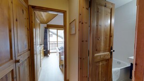 A wooden hallway leading to a balcony with a view of a building. - Quiet 2-room apartment, ca. (Sils/Segl Maria)