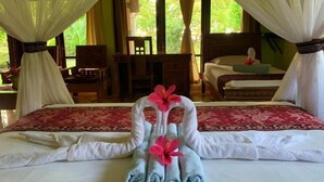 A hotel room with a bed, a desk, and a chair. - Budi Sun Resort (Maumere)