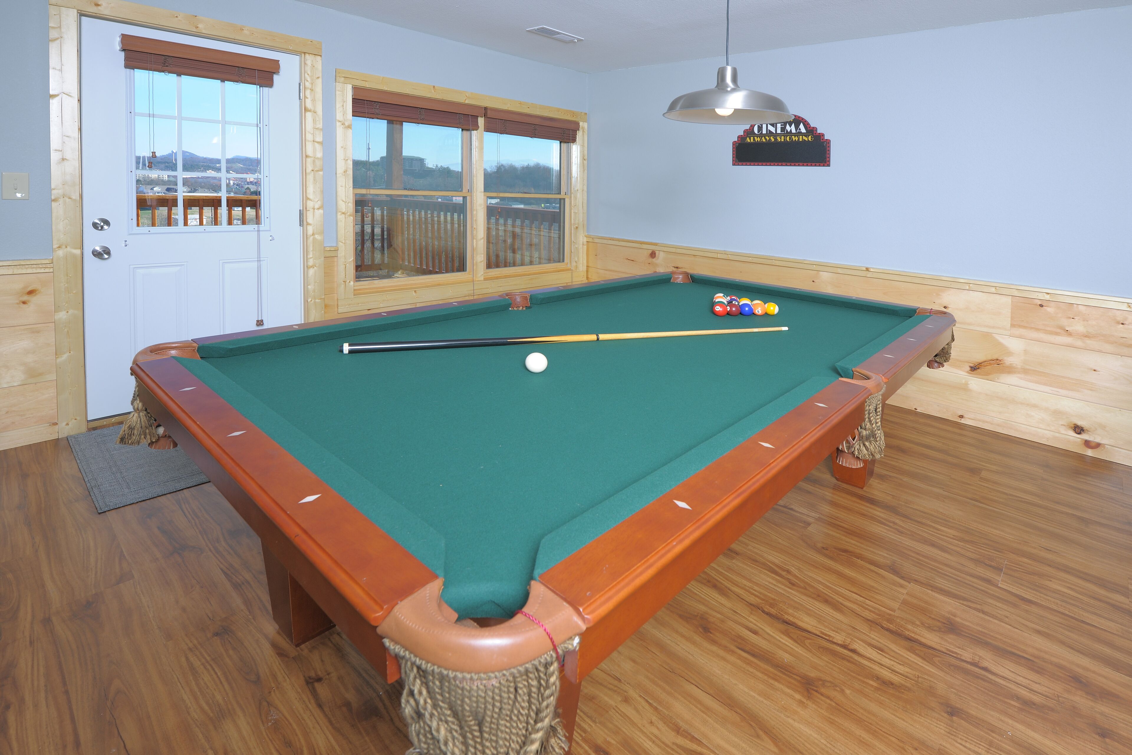 Une table de billard recouverte d’un drap vert, avec des bords en bois et un queue de billard.