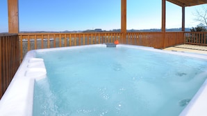 Un jacuzzi con terraza de madera y vista despejada del paisaje circundante.