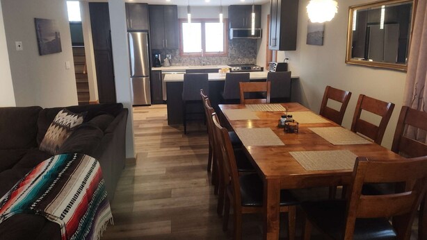 A modern kitchen with dark cabinets, stainless steel appliances, and a central island. - Killington Mountain View Townhouse (Killington)