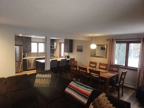 Relax in a clean, contemporary space with a sofa, dining area, and kitchen.