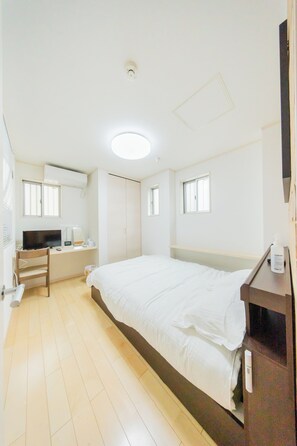 A bedroom with a bed, a desk, a chair, and a TV. - Otsuka No Yado (Tokyo)