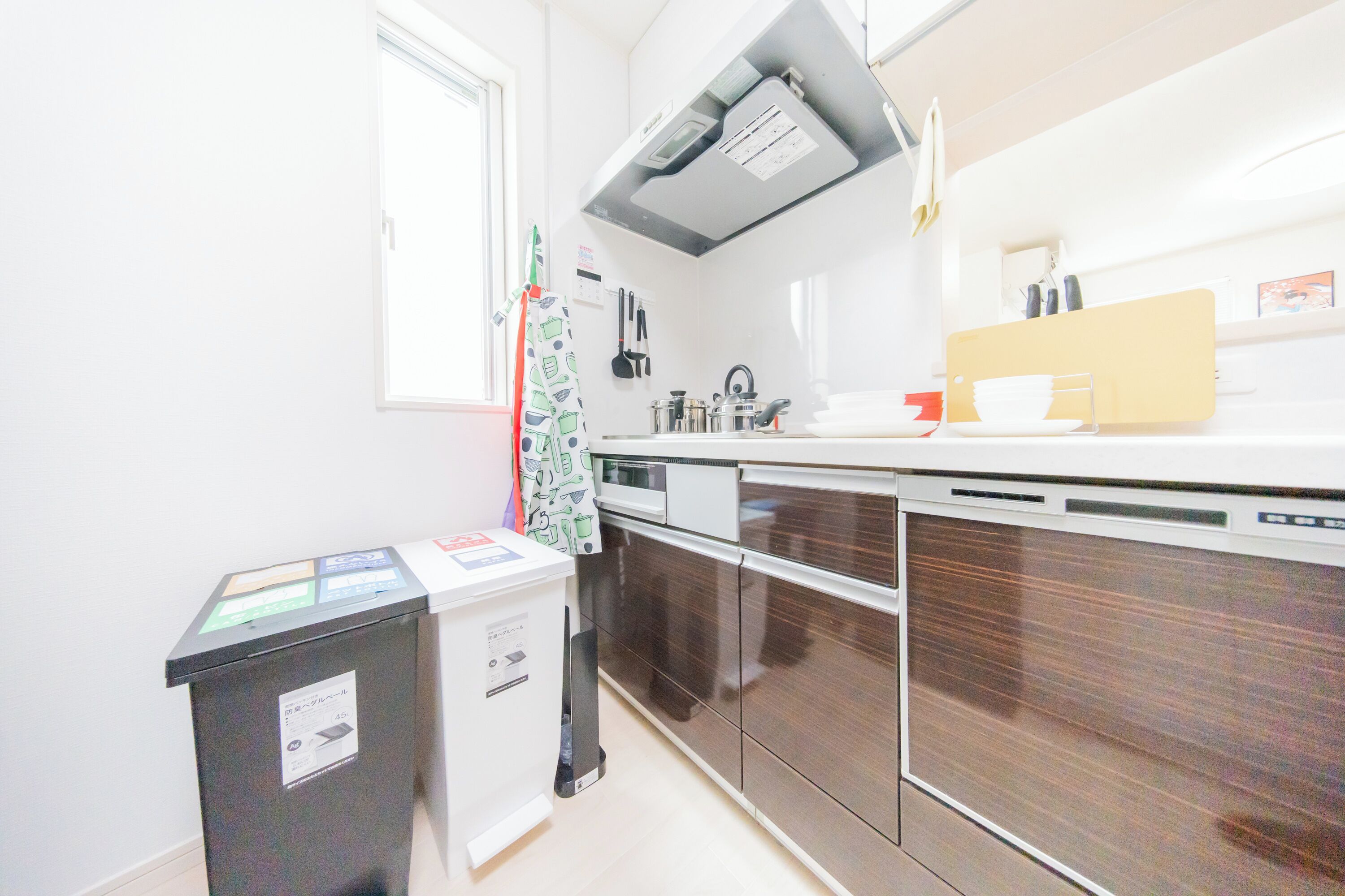 A modern kitchen with stainless steel appliances, a dishwasher, and a window providing natural light.