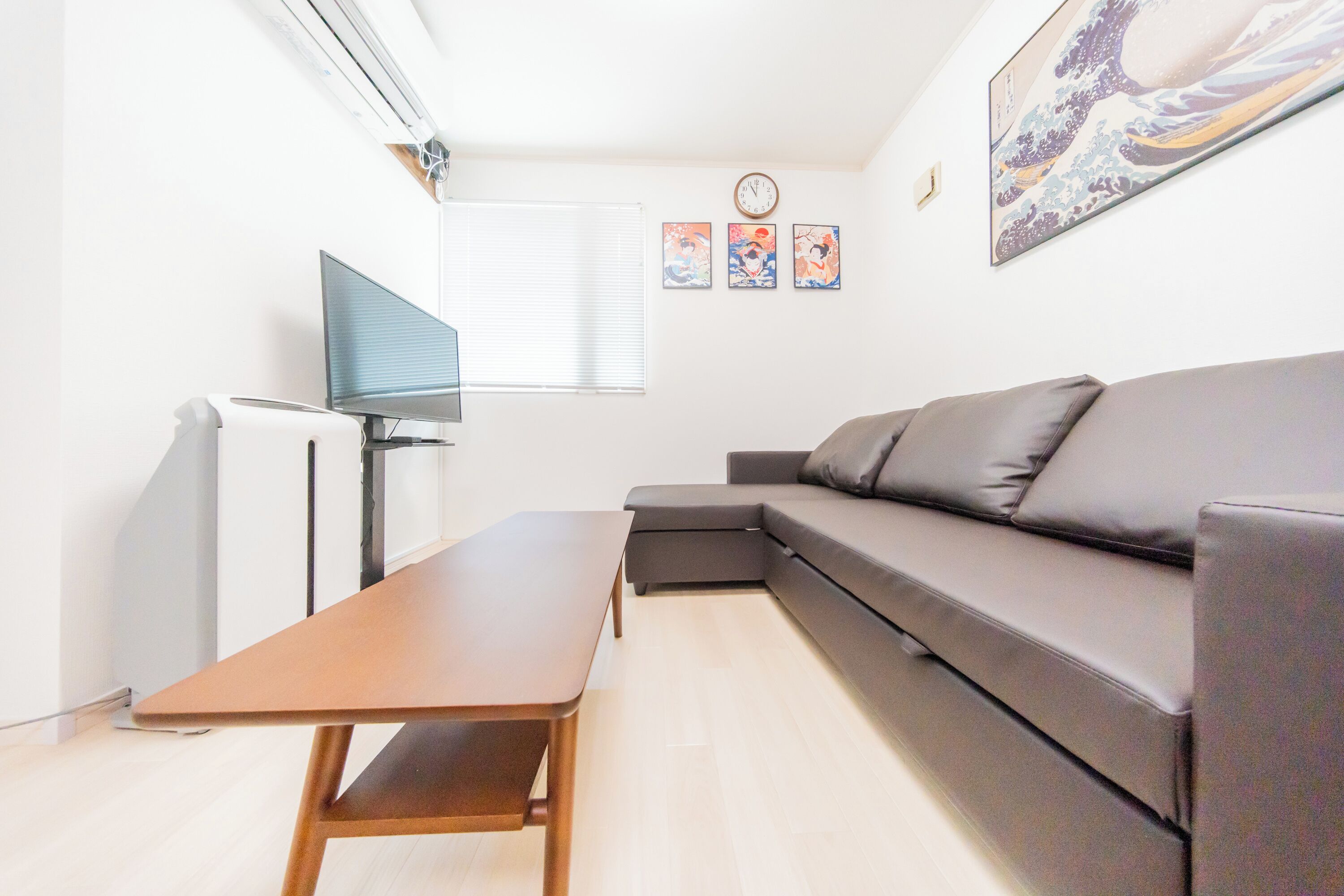 Un salon moderne avec un canapé, une table basse et un téléviseur à écran plat.