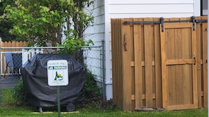 A covered parking sign for Harbor Pines, #8, with a wooden fence and a gate in the background. - Eagle Harbor- Harbor Pines: Savor History and Nature at Harbor Pines Cottage (Eagle Harbor)