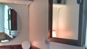 A bathroom with a sink, mirror, and a wooden vanity. - Eagle Harbor- Harbor Pines: Savor History and Nature at Harbor Pines Cottage (Eagle Harbor)