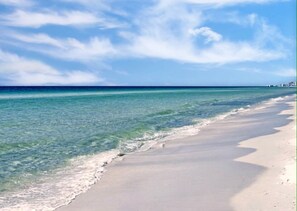 Una playa con agua azul cristalina y una orilla arenosa.
