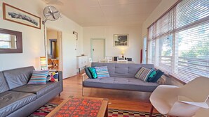 Een woonkamer met een bank, fauteuil en een kamerbreed tapijt.