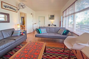 Ein Wohnzimmer mit einer Couch, einem Sessel und einem gemusterten Teppich.