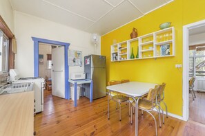 Eine kompakte Küche mit Essbereich, ausgestattet mit einer Mikrowelle, einem Kühlschrank und einem kleinen Tisch mit Stühlen.