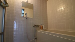 A bathroom with a shower, a bathtub, and a mirror on the wall. - Hikari No Yado (Anan)