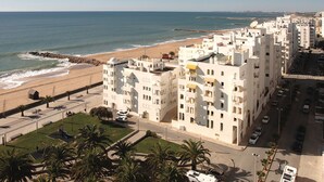 A coastal hotel with multiple floors, a beach view, and a parking area. - Lazenby Red Apartment, Balcony (Quarteira)