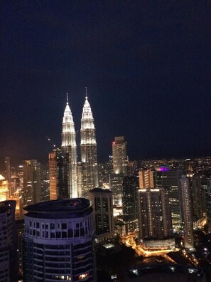 A nighttime cityscape with prominent twin towers and surrounding high-rise buildings. - Best Homestay (Kuala Lumpur)