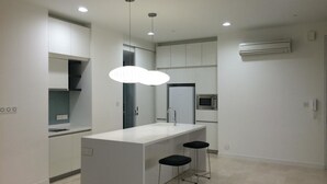 A modern kitchen with a central island, bar stools, and recessed lighting. - Best Homestay (Kuala Lumpur)