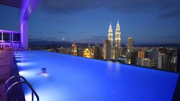 A rooftop infinity pool with a city skyline view, including the Petronas Towers. - Best Homestay (Kuala Lumpur)